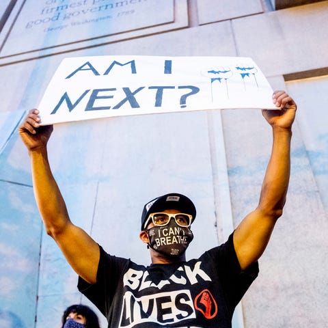 Romeo Ceasar holds a sign during a Black Lives Mat