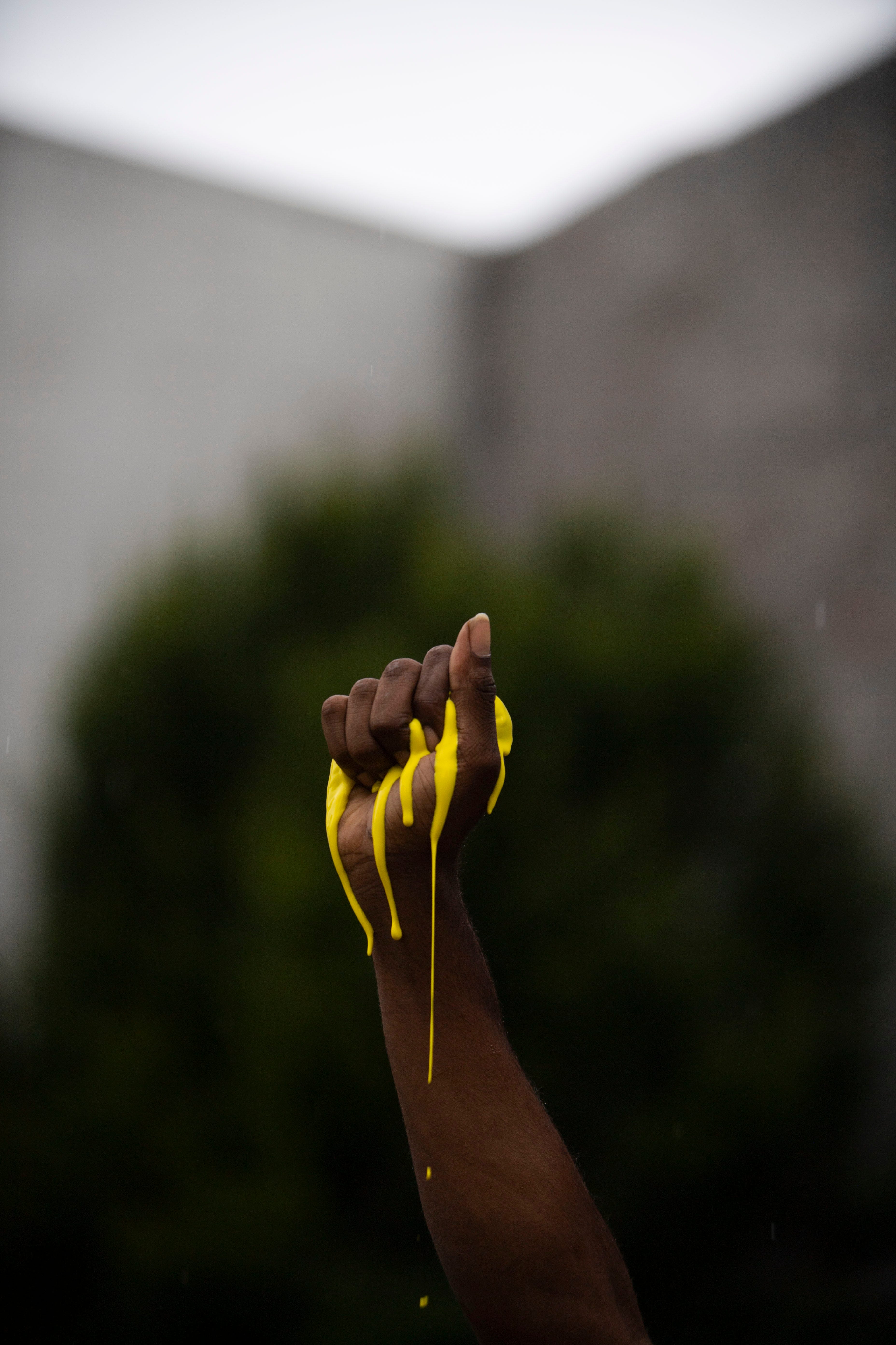 Yellow paints spills out of Tracy Boyd's hand, symbolizing the location of where a "Black Lives Matter" mural is planned in Jackson, Tenn., Wednesday, July 22, 2020.