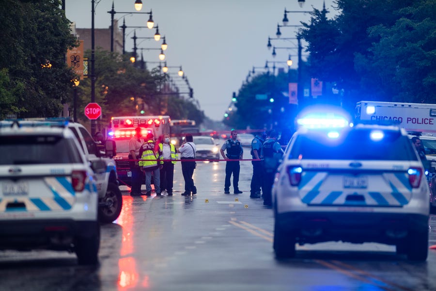 Chicago police investigate the scene of a mass shooting where more than a dozen people were shot in the Gresham neighborhood July 21.