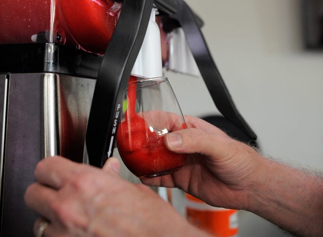 John Colbert pulls a cold house-made cherry-lime wine slushie with red wine on Wednesday, July 1, 2020.