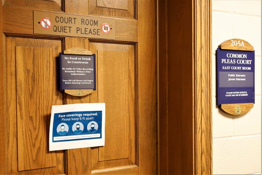 A sign on the door of one of the Fairfield County Common Pleas courtrooms reminds citizens attending legal hearings to wear a mask and maintain a safe distance from fellow attendees during the coronavirus pandemic.