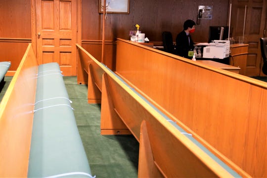 Dan Bellerive, the bailiff in Fairfield County Common Pleas Judge Richard Berens' courtroom, works on paperwork in the courtroom, whose benches have been marked to allow people sitting in the courtroom to maintain safe distances from one another during the coronavirus pandemic.