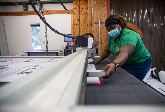 Carmen Marcellus, a pre-press operator at Target Print & Mail, aligns a laser to cut signs for a customer Friday, July 24, 2020.