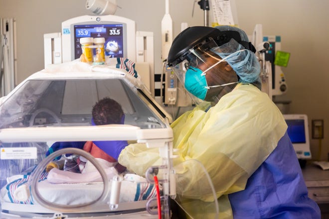 Neonatal Intensive Care Unit registered nurse LaShayla Yates, with the University of Mississippi Medical Center, takes care of a baby born to a COVID-positive mom.