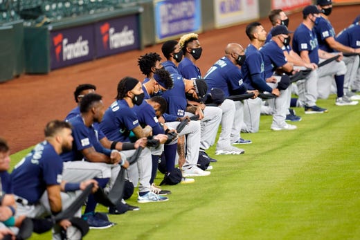 Seattle Mariners players kneel for social justice before a baseball game against the Houston Astros Friday, July 24, 2020, in Houston.