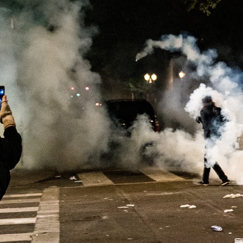 A protester takes video of another protester wreat