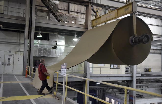 Mike Gower a dry end team member at International Paper uses a lift to transport a new roll of paper while working at the plant in Henderson Nov. 9, 2016.
