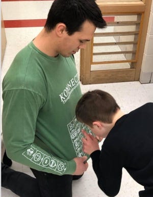 Korey Kleinhans, a special education gym teacher in the Oshkosh Area School District, watches as a student uses the images on his Konnect T-shirt to communicate what he wants.
