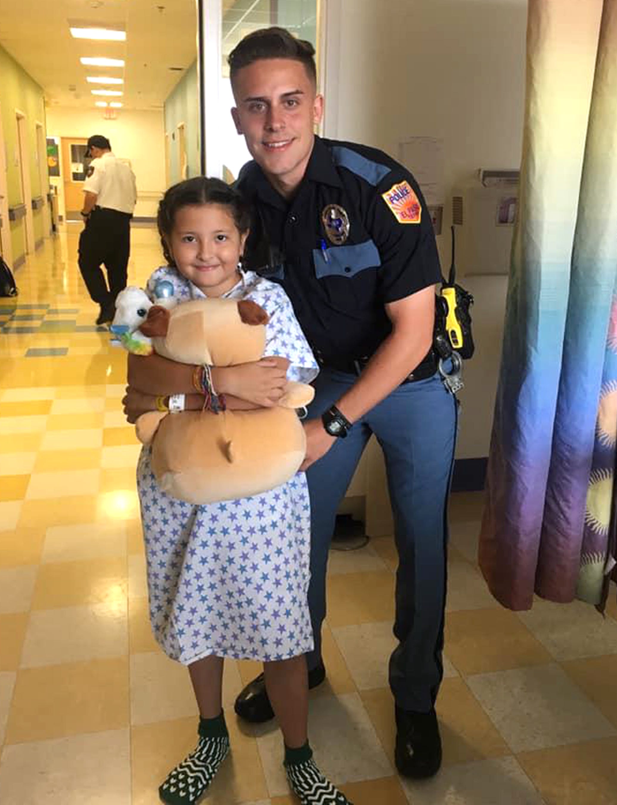 Mario De Alba's daughter Erica De Alba, then 9 years old, suffered a wound to her leg in the Walmart mass shooting on Aug. 3, 2019. Here she is comforted in an El Paso hospital by a stuffed animals and a visiting El Paso police officer.