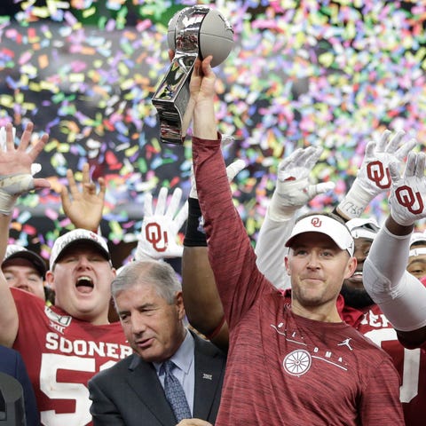 Oklahoma coach Lincoln Riley (holding trophy) and 