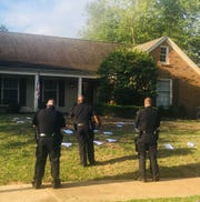Officers survey flyers littered in the yard of Shelby County Commission Chairman Mark Billingsley.