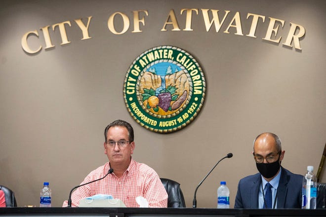 Atwater Mayor Paul Creighton, left, and City Attorney Fran Splendorio, right, attend an Atwater City Council meeting in Atwater, Calif., Monday, July 27, 2020.  Gov. Gavin Newsom for the first time is using his newly won financial power to withhold tens of thousands of dollars from Atwater and Coalinga in California's Central Valley because they are defying state health orders by allowing all businesses to remain open during the pandemic. Officials in the two cities say they won't give in.