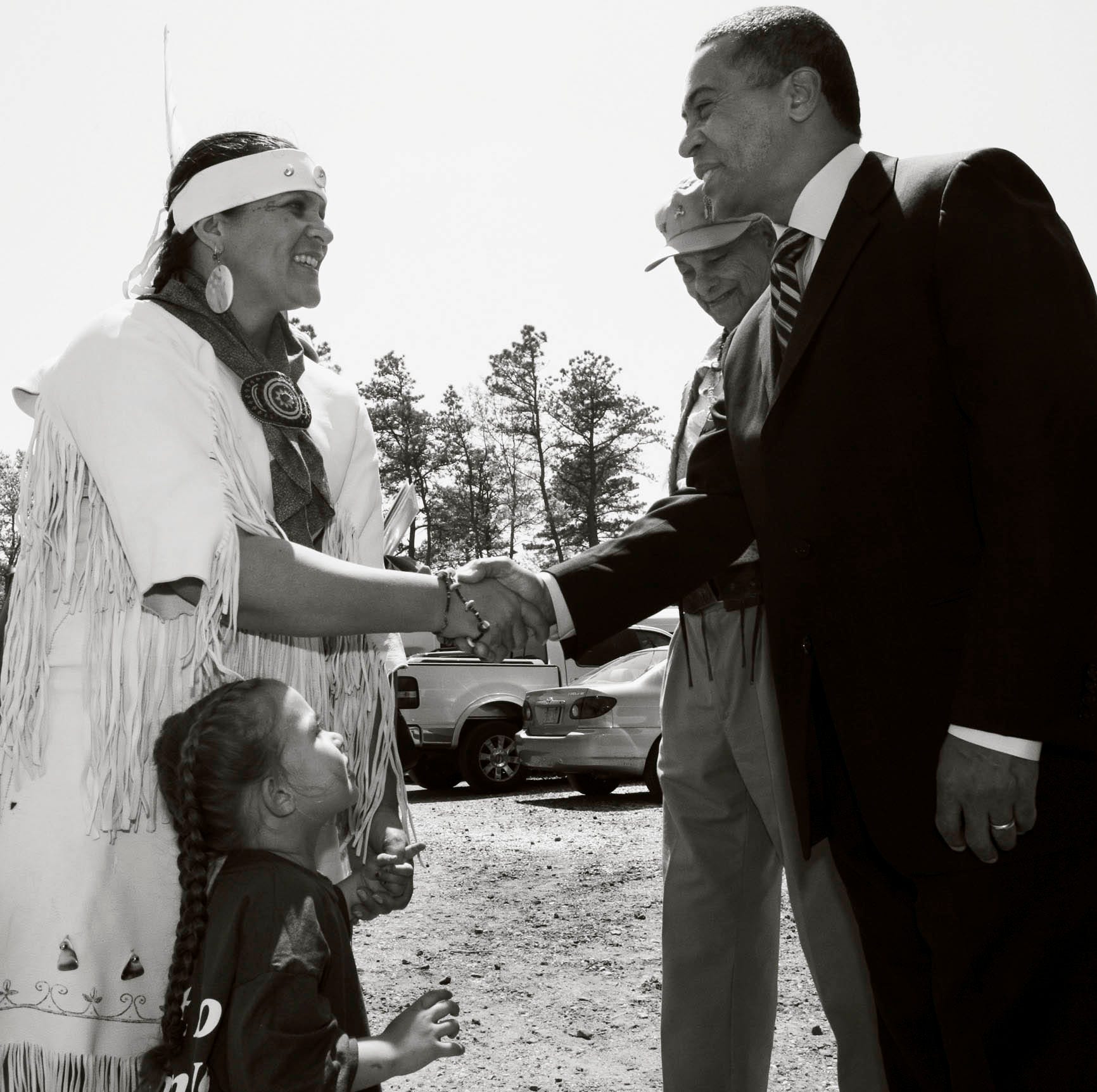 Mashpee Wampanoag tribal citizen Jessie "Little Doe" Baird shakes hands with Massachusetts Gov. Deval Patrick in 2007 during his visit to tribal headquarters to congratulate the tribe on its official recognition by the federal government. Baird's daughter, Mae Alice, and Tribal Chief Vernon Lopez look on.