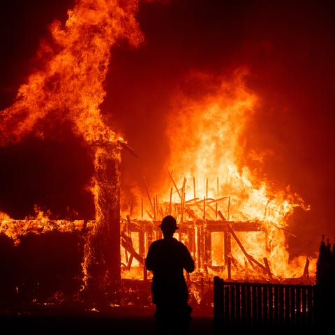 A home burns as the 2018 Camp Fire rages through P