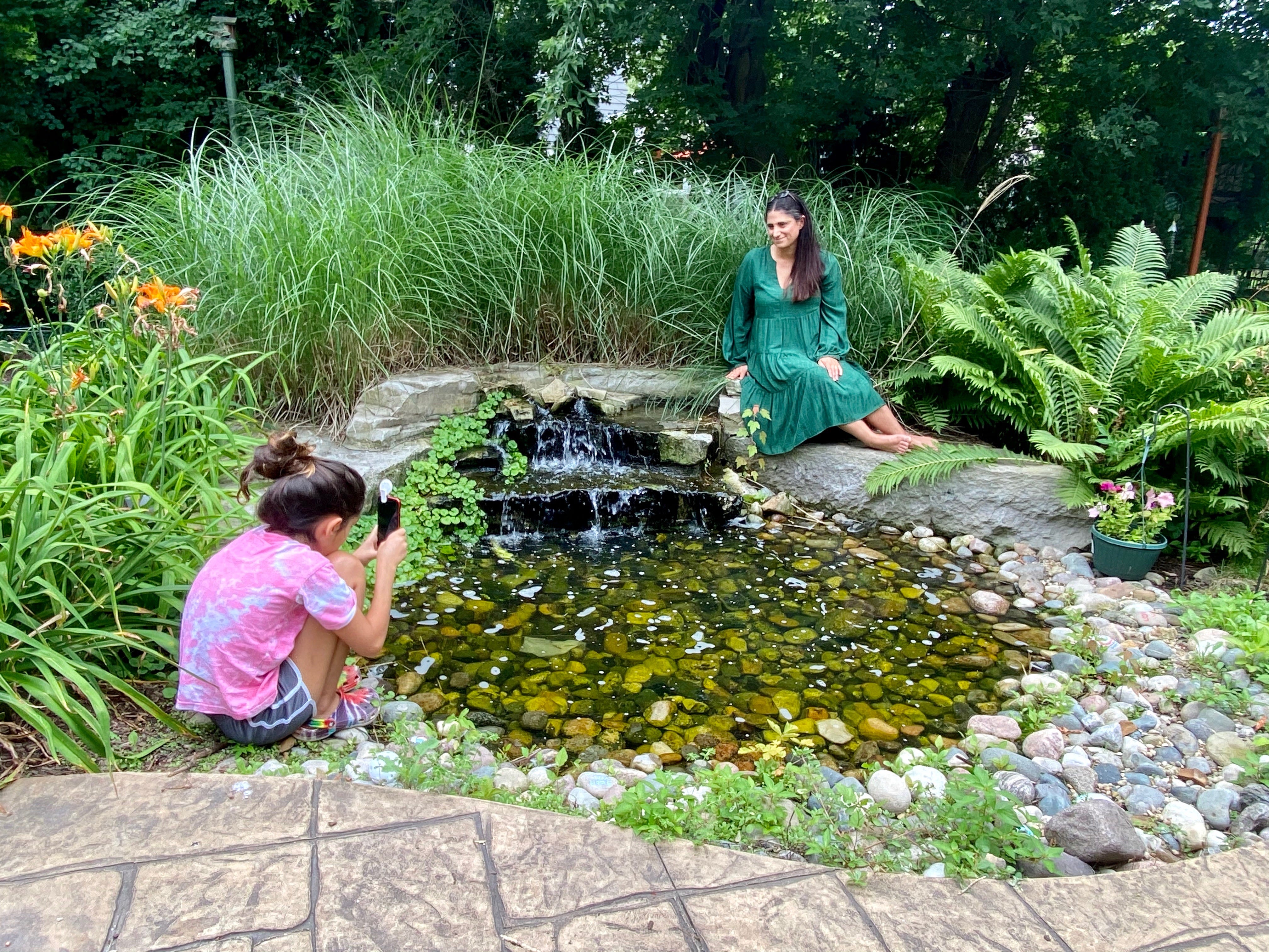 Dr. Mona Hanna-Attisha poses as her daughter, Layla, takes her picture in the backyard of their home in Michigan.