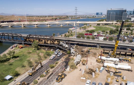 Crews work the site of a train derailment and bridge collapse at the Salt River Union Pacific Bridge at Tempe Town Lake on July 30, 2020, in Tempe. The train derailed causing a fire and the bridge's collapse on July 29.