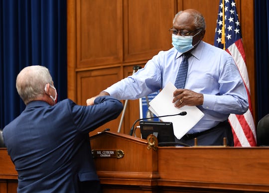 Dr. Anthony Fauci (L), director of the National Institute for Allergy and Infectious Diseases, fist bumps Committee Chairman James Clyburn, D-S.C.