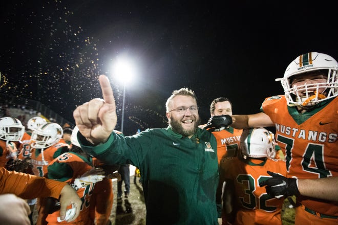 Mandarin head football coach Bobby Ramsay is swarmed by his team after winning a 2018 state semifinal against Sarasota Riverview. The uncertainty of the 2020 season leaves confusion and frustration for many coaches around Jacksonville. [James Gilbert/For The Florida Times-Union]