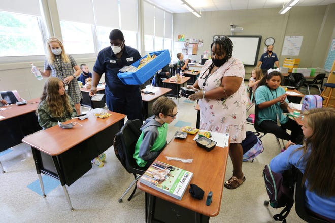 Ray Williams, a member of the janitorial staff at the Corinth Middle School and Stephanie Patterson, a cafeteria worker, with the Corinth School District, pass out the lunches from the cafeteria to the children in their classrooms on Monday, July 27, 2020 in Corinth, Miss.