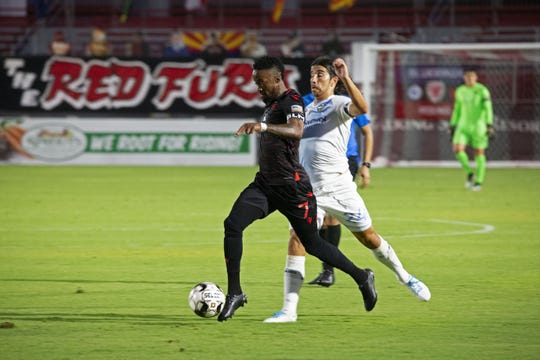 August 1, 2020; Tempe, AZ, USA; Forward Junior Flemmings streaks past El Paso midfielder Yuma to take a strike on net. Flemmings records one goal in the 3-1 victory over El Paso Locomotive. Mandatory Credit: Justin Toumberlin/The Arizona Republic via USA TODAY NETWORK