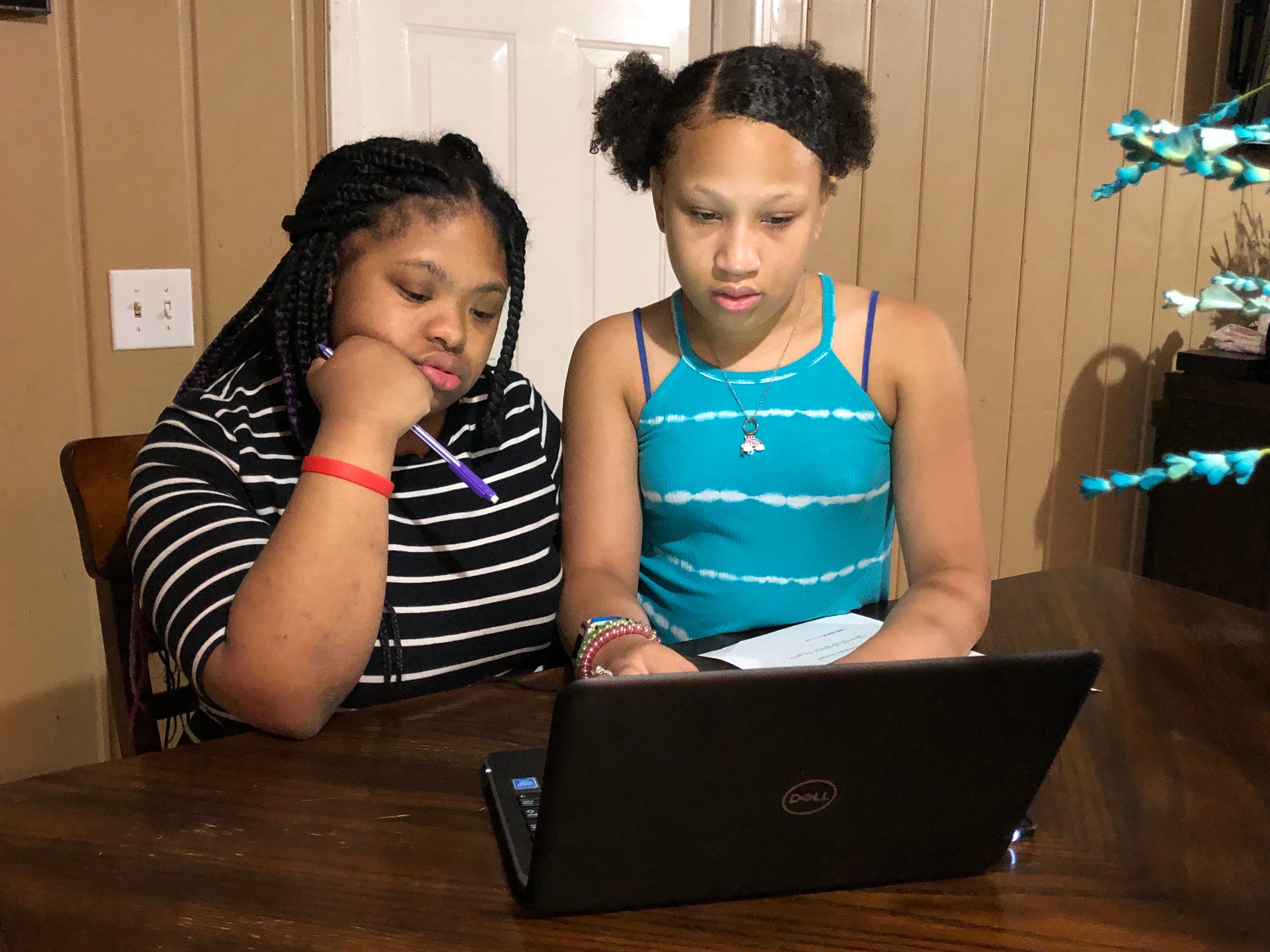 Abigail Alexander, right, a fifth grader at Head Middle Magnet School, helps her sister, Anaya, an exceptional education student at Maplewood High School, try to sign in online for the first day of virtual learning for Metro Nashville Public Schools on Aug. 4.