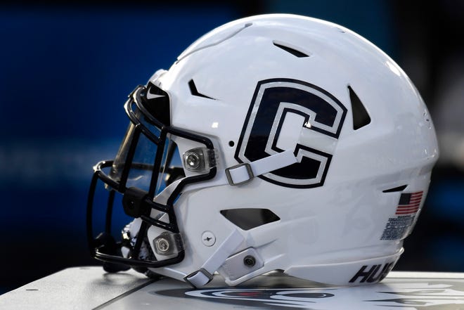 FILE - In this Sept. 7, 2019, file photo, Connecticut football helmet rests on the sideline during an NCAA college football game in East Hartford, Conn. UConn has canceled its 2020-2021 football season, becoming the first FBS program to suspend football because of the coronavirus pandemic.(AP Photo/Jessica Hill, File)