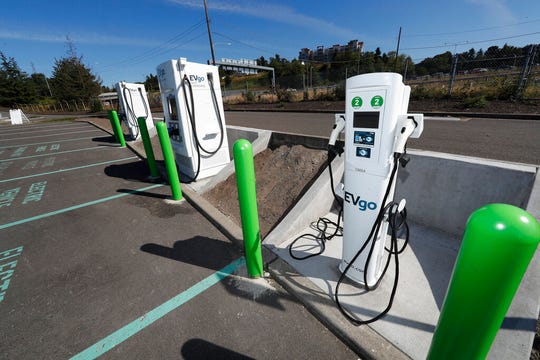 In this Sunday, July 21, 2019, file photograph, electric car charging stations stand along Interstate 5 outside the LeMay Auto Museum in Tacoma, Wash. Public charging plugs around the world hit the 1 million mark sometime in May, according to the recent tally by BloombergNEF.