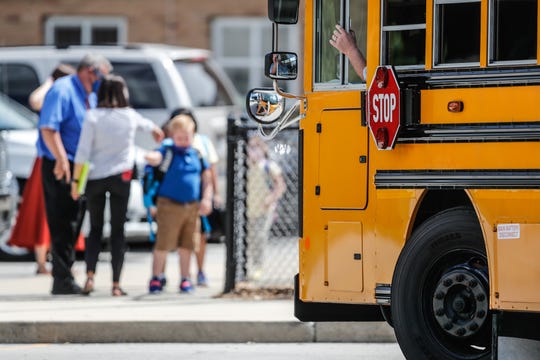 A bus waits to take students home from Homecroft Elementary School in Indianapolis on the first day of classes Wednesday.