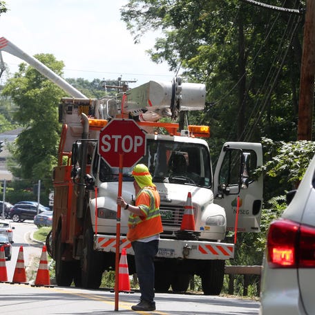 A NYSEG workers closes a portion of Baldwin Place Road in Mahopac as crews work on utility lines following Tropical Storm Isaias Aug. 5, 2020.