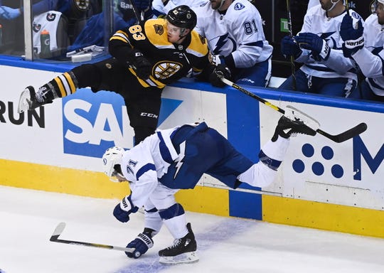 Boston Bruins center Karson Kuhlman (83) hits Tampa Bay Lightning center Anthony Cirelli (71) during the third period of an NHL hockey playoff game  Wednesday, Aug. 5, 2020 in Toronto.