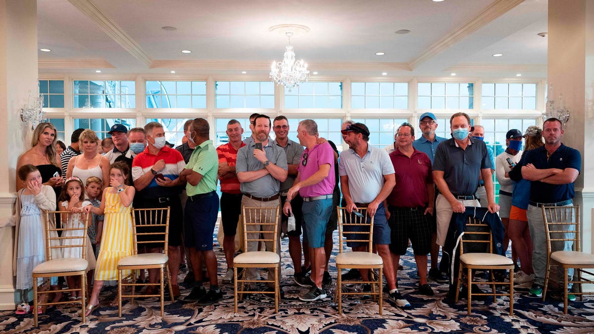 Country club members, few wearing facemasks, await the US president's arrival ahead of a news conference in Bedminster, New Jersey, on August 7, 2020. (Photo by JIM WATSON / AFP) (Photo by JIM WATSON/AFP via Getty Images) ORIG FILE ID: AFP_1WD2NW