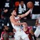 Phoenix Suns' Devin Booker (1) goes to the basket over Miami Heat's Andre Iguodala, left, and Tyler Herro, right, during the second half of an NBA basketball game, Saturday, Aug. 8, 2020, in Lake Buena Vista, Fla. The suns won 119-112. (AP Photo/Ashley Landis, Pool).