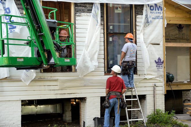Workers install the first window at the Mote Morris House on Monday. [Cindy Peterson/Correspondent]