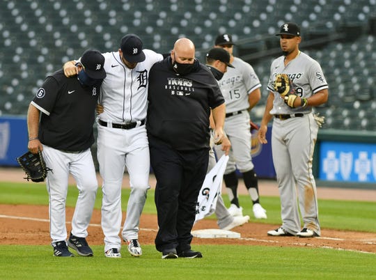 Tigers manager Ron Gardenhire, left, and head athletic trainer Doug Teter, right, help C.J. Cron off the field during Monday's game.