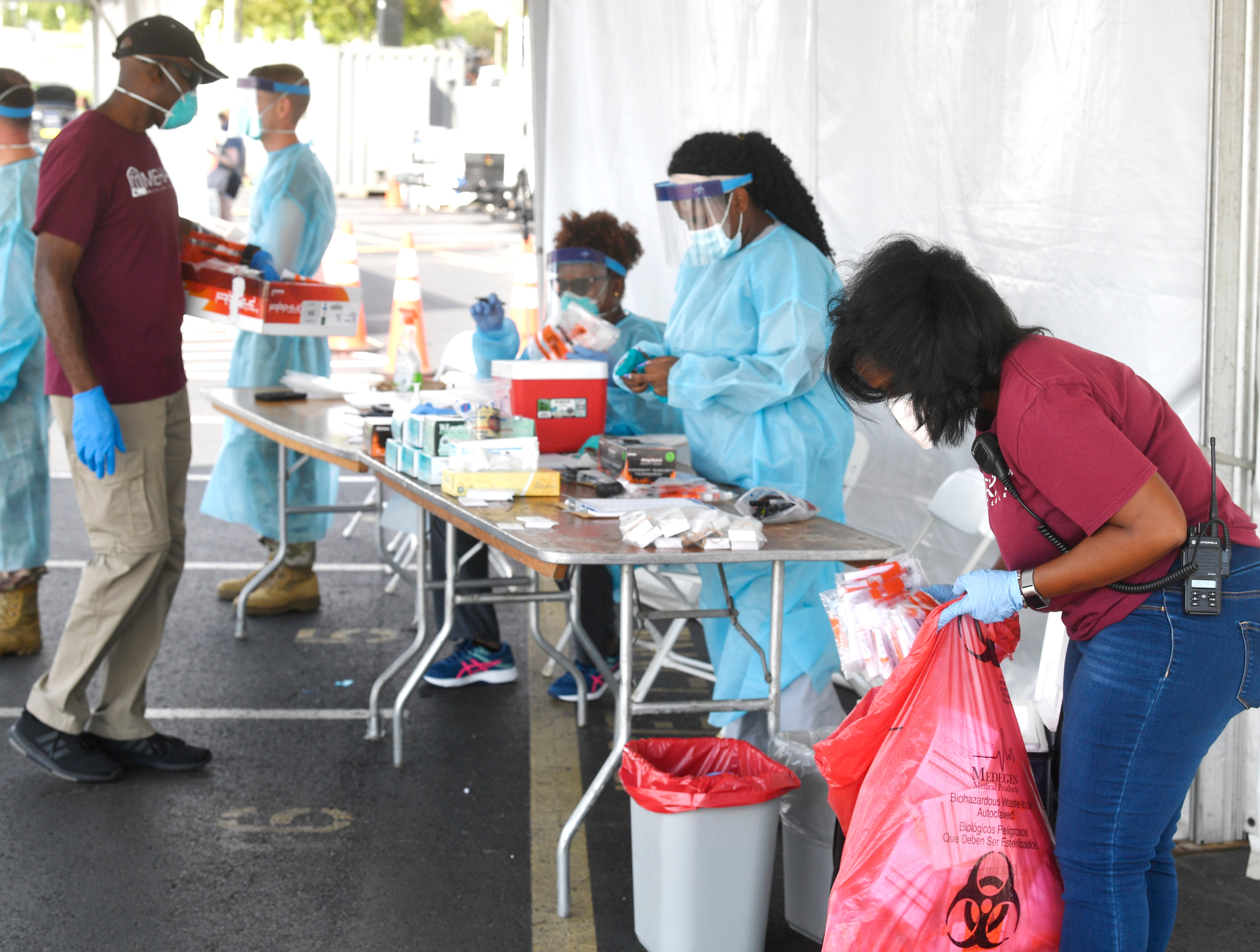 Amber DuVentre, right, picks up tests as Anthony Thomas, left, drops new test kits out. Many Meharry employees have essentially been keeping Nashville's 3 COVID testing sites going since March in Nashville, Tenn. Tuesday, Aug. 11, 2020 