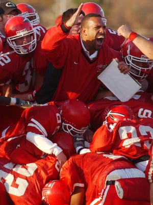 Paulsboro head coach Glenn Howard celebrates with his team after the Red Raiders defeated Woodbury 26-20 in the South Jersey Group 1 semifinals on Nov. 17, 2001.