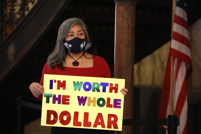The Pay Equity Coalition of Rochester held a press conference to raise awareness on how Black women get paid less, Jackie Ortiz, co founder of the group and councilmember on the Rochester City Council, holds a sign.