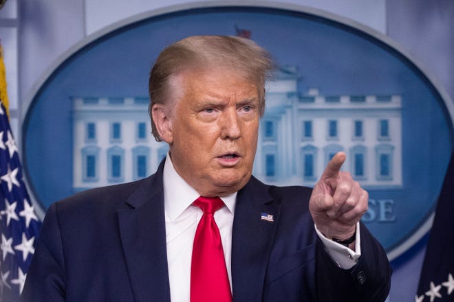 President Donald Trump points to a question as he speaks during a briefing with reporters in the James Brady Press Briefing Room of the White House.