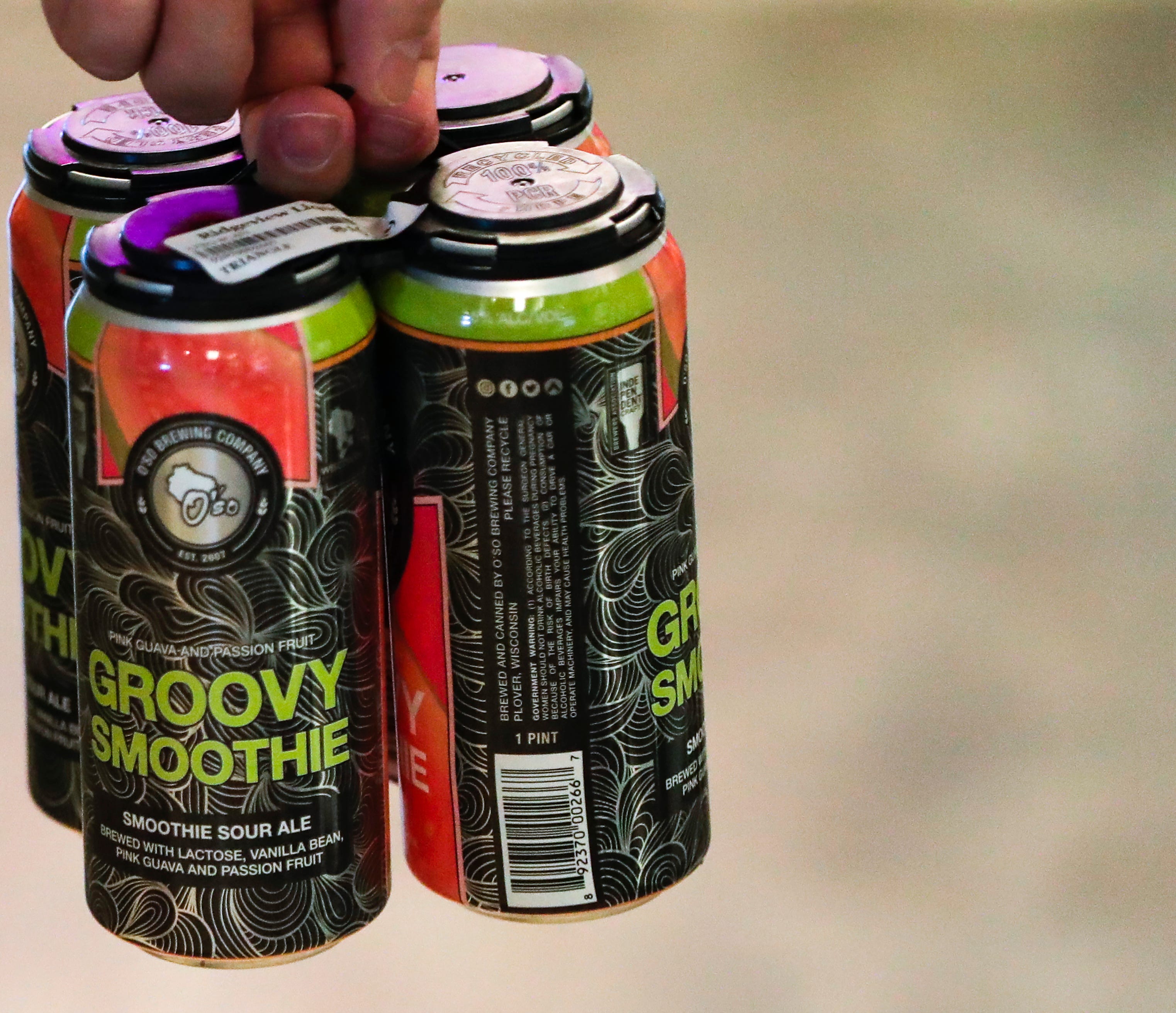 Brian Kopfhammer holds a four-pack of Groovy Smoothie, an ale made by O'so Brewing Co. in Plover, while shopping at Ridgeview Liquor in Ashwaubenon.