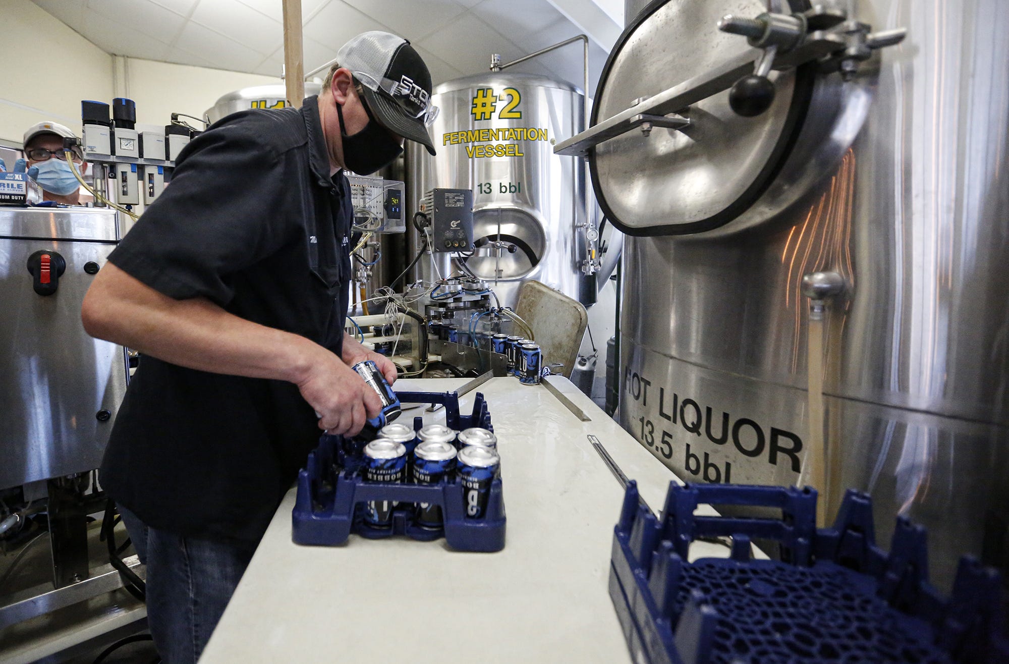 Mike Timm of De Pere loads freshly filled cans of Blu Bobber beer into a rack at Fox River Brewing Co. in Oshkosh. The brewery buys cans directly from suppliers and also through Midwest Mobile  Canning, a Chicago-based company that cans beer for breweries throughout the Midwest.