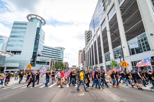 Proud Boys cross Michigan Avenue on Rose Street in Kalamazoo, Saturday.
