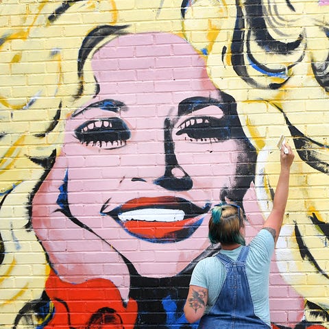 Artist Kim Radford paints a mural of country music