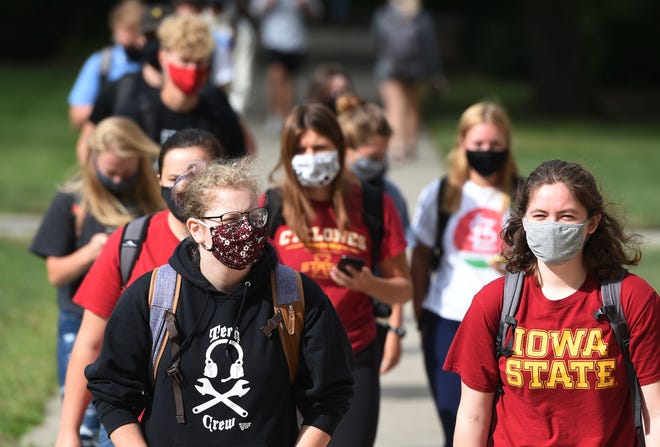 Iowa State University students wear masks while walking to their classes during the passing time on the first day of classes on Monday, Aug. 17, 2020, in Ames, Iowa.
