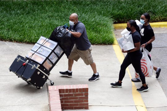 College students move in for the fall semester at North Carolina State University in Raleigh. The school announced it would close residence halls less than a week after moving classes online because of COVID-19.