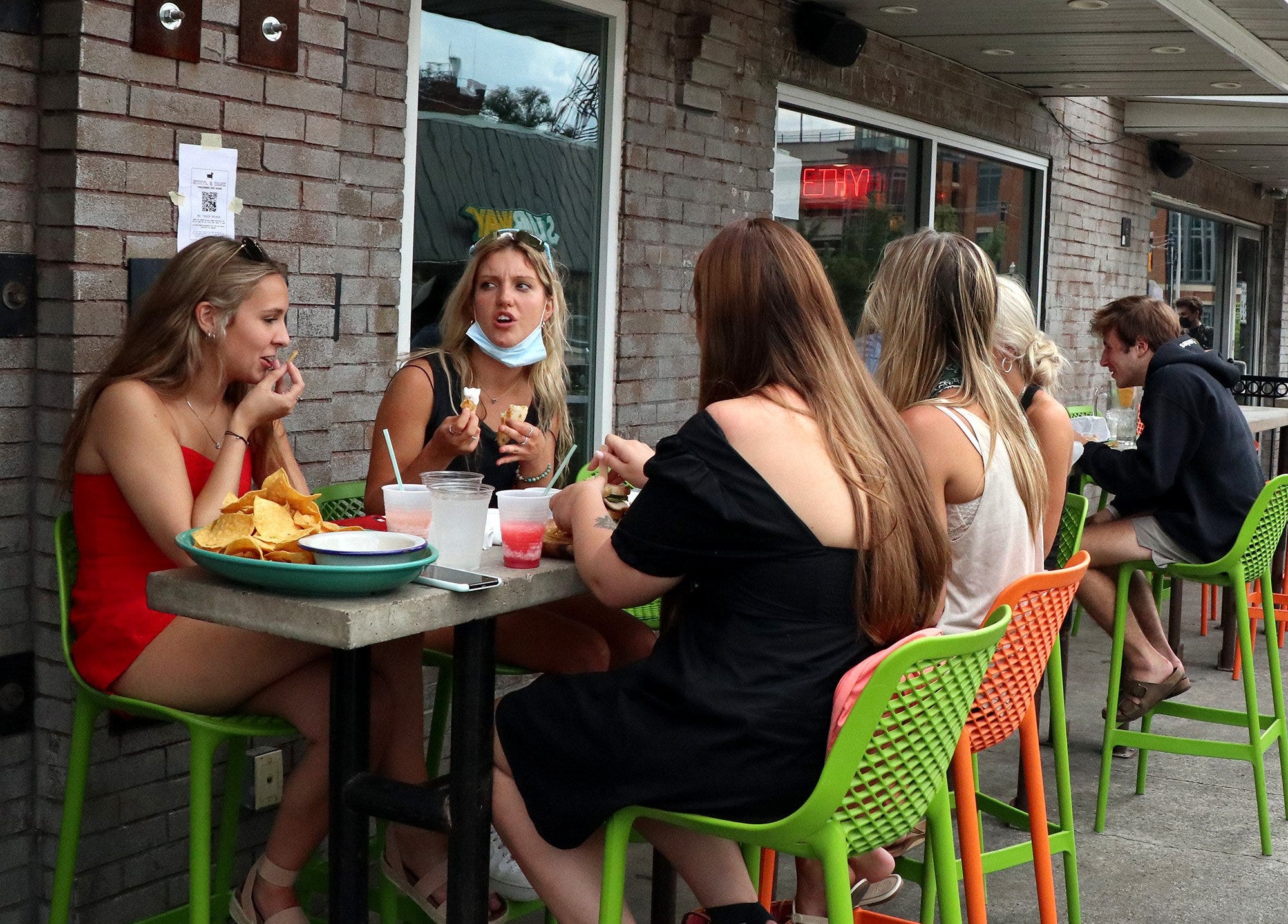 From left, Georgia Santino, Claire Tzagournis, Claudia Santino and others eat on the patio at Ethyl and Tank on Aug. 7 near Ohio State. Georgia Santino attends Columbus State, and her sister Claudia goes to Oregon University; Tzagournis attends Miami University of Ohio.