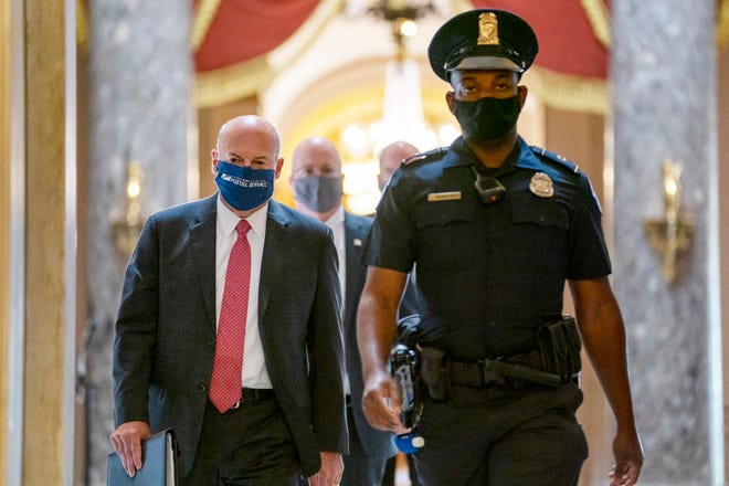 Postmaster General Louis DeJoy, left, is escorted to House Speaker Nancy Pelosi's office on Capitol Hill in Washington on Aug. 5, 2020. Several individuals including candidates for public office sued President Donald Trump and the U.S. Postal Service's new postmaster general in New York on Aug. 17, 2020 to ensure adequate funding for postal operations. The lawsuit was filed in Manhattan federal court as multiple lawsuits were threatened across the country as a response to comments the president recently made and actions taken by DeJoy to change operations at post offices nationwide. 