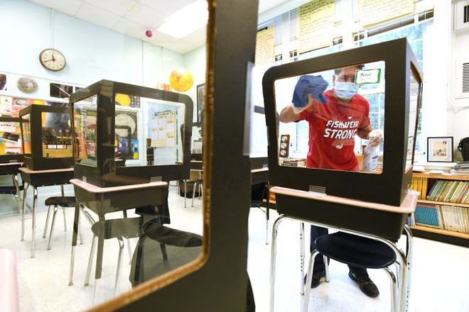 Renato Valdres with ABM demonstrates the contact cleaning that will take place on a regular basis in the classrooms at Fishweir Elementary School.  [Bob Self/Florida Times-Union]