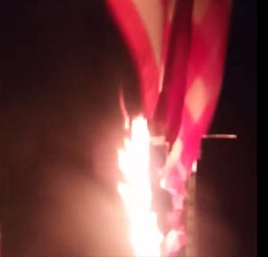 This screenshot of a video posted on Facebook shows an American flag as it is engulfed by flames at the home of a village of Waukesha family on Aug. 16. The flag was one of two destroyed by vandals, along with a Biden political sign.