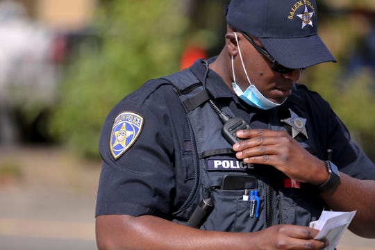 Salem Police Officer Tony Fultz uses his radio while working a traffic accident in Salem, Oregon, on Wednesday, Aug. 19, 2020. Salem Police department's new $11.2 million radio system operates at 800-megahertz and allows officers to easily communicate with other local agencies. 
