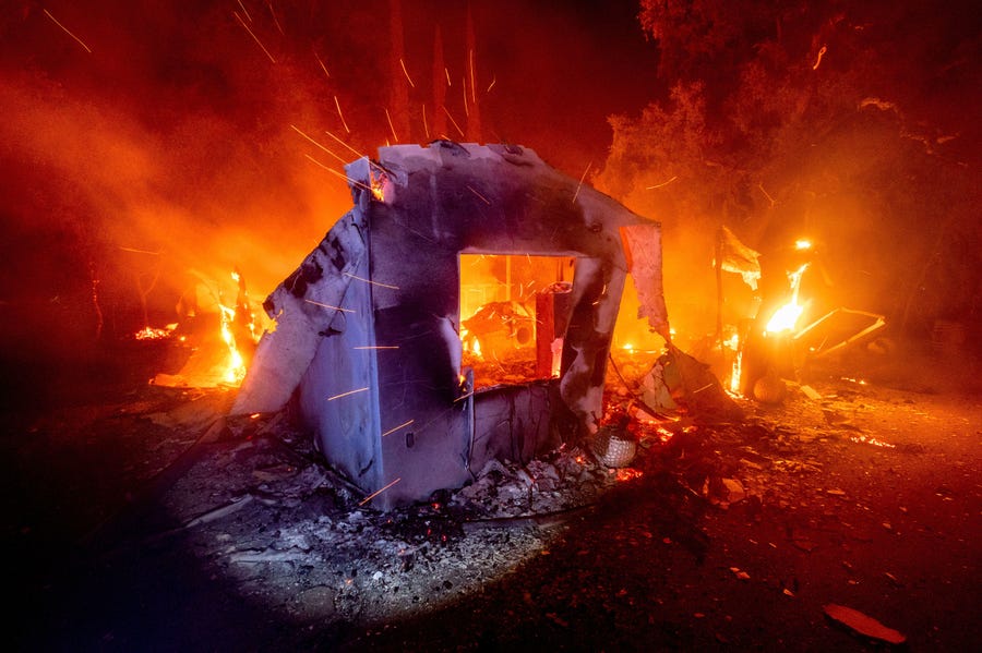 Flames from the LNU Lightning Complex fires consume a home in unincorporated Napa County, Calif., on Aug. 19, 2020. Fire crews across the region scrambled to contain dozens of wildfires sparked by lightning strikes.